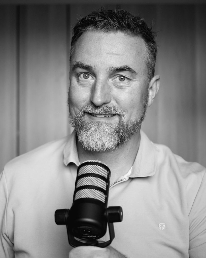 André van Essen met een podcastmicrofoon in de hand